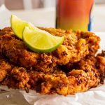 Two Delicious Conch Fritters With Sliced Limes Served as an Appetizer